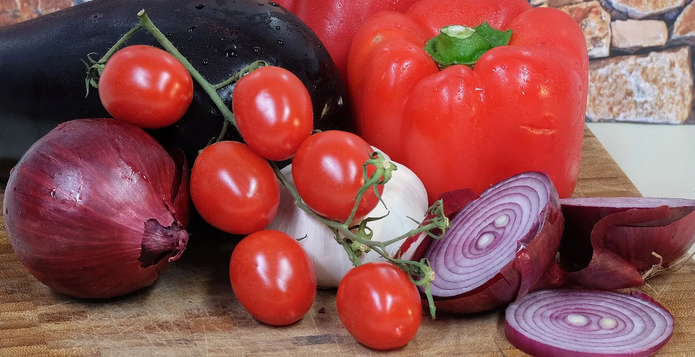 Cebolla, jitomate y pimiento sobre una tabla